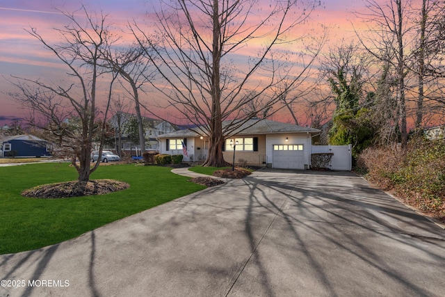 ranch-style house with a yard, concrete driveway, and an attached garage