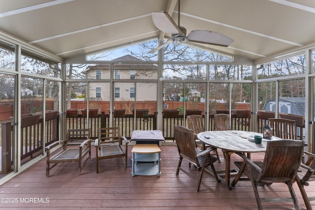 sunroom / solarium with a ceiling fan and vaulted ceiling