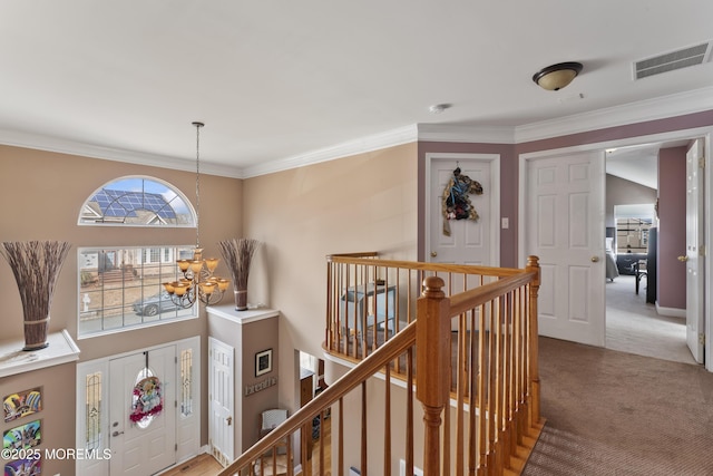 corridor with a chandelier, light colored carpet, an upstairs landing, visible vents, and ornamental molding