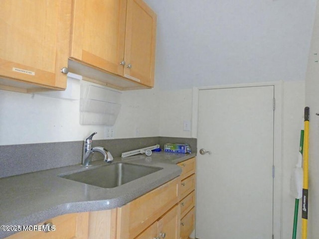 kitchen with a sink and light brown cabinetry