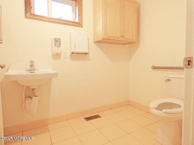 bathroom with baseboards, visible vents, toilet, and tile patterned floors