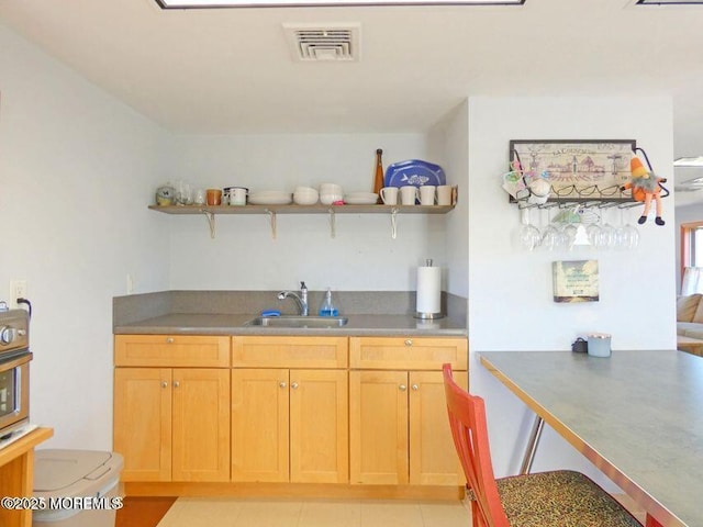 kitchen featuring light tile patterned floors, visible vents, a sink, and open shelves