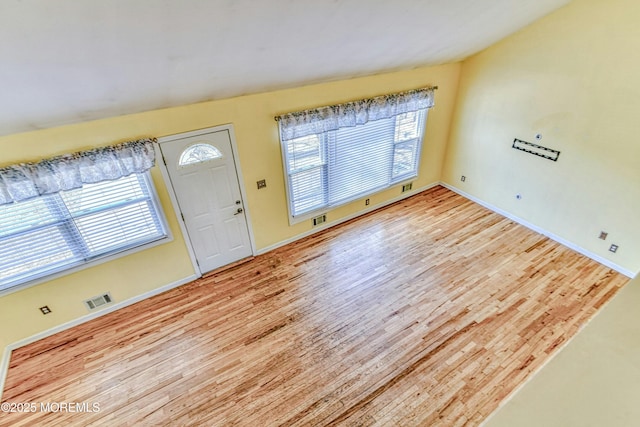 entryway featuring a wealth of natural light, wood finished floors, visible vents, and baseboards