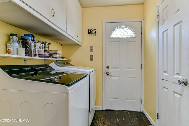 laundry room featuring baseboards, cabinet space, dark wood finished floors, and washing machine and clothes dryer