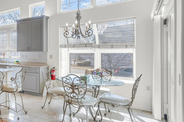 dining room with light tile patterned floors, a chandelier, and a towering ceiling