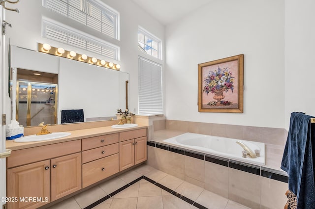 bathroom with a garden tub, a sink, tile patterned floors, double vanity, and a stall shower