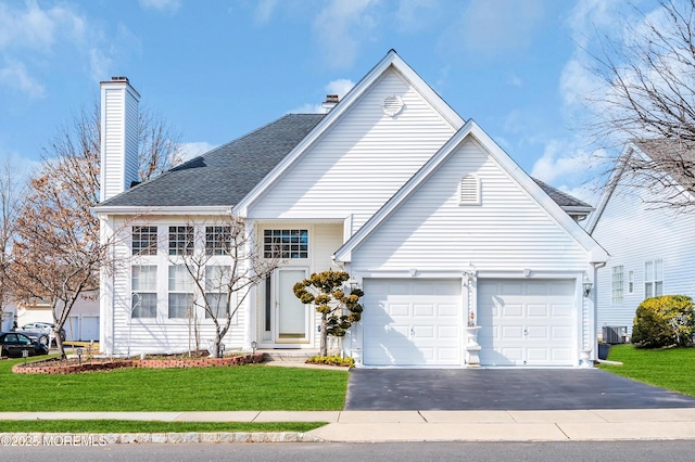 traditional-style house with driveway, central air condition unit, a chimney, and a front yard