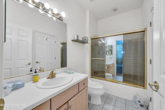 bathroom with combined bath / shower with glass door, vanity, toilet, and tile patterned floors