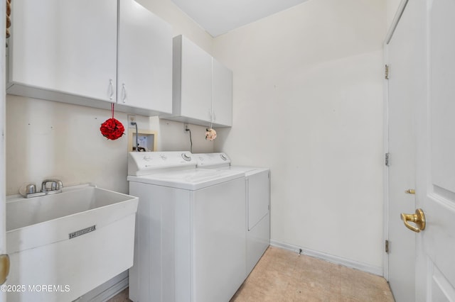 clothes washing area with separate washer and dryer, a sink, cabinet space, and baseboards