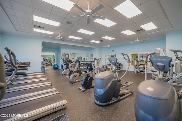 exercise room featuring a drop ceiling, visible vents, and a ceiling fan