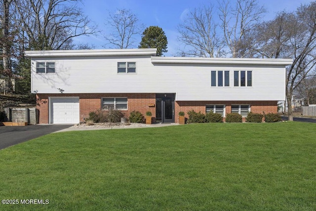 view of front of house featuring a garage, driveway, brick siding, and a front yard