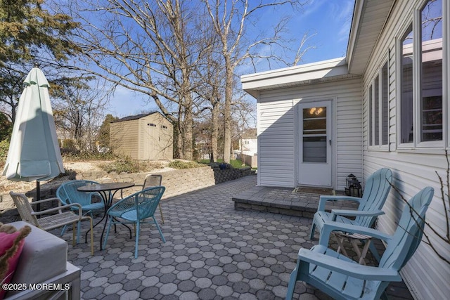 view of patio with an outbuilding, outdoor dining space, and a storage shed