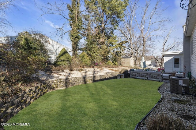 view of yard with central AC unit and fence