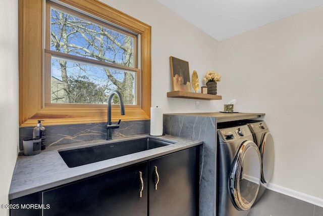 laundry area featuring washing machine and clothes dryer, cabinet space, and a sink