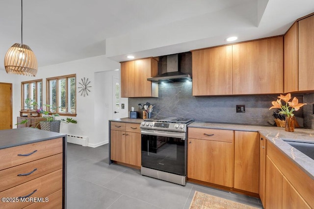 kitchen featuring a baseboard radiator, hanging light fixtures, gas range, wall chimney exhaust hood, and backsplash