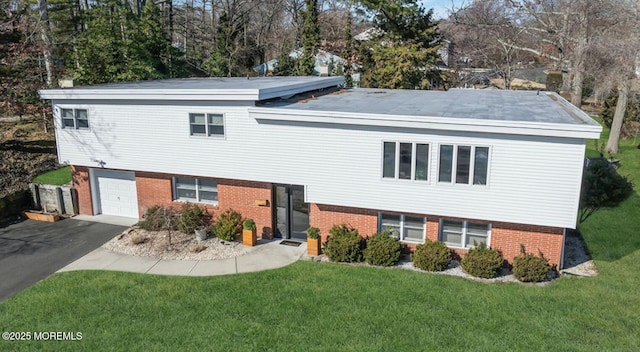 view of front of house with brick siding, driveway, an attached garage, and a front yard