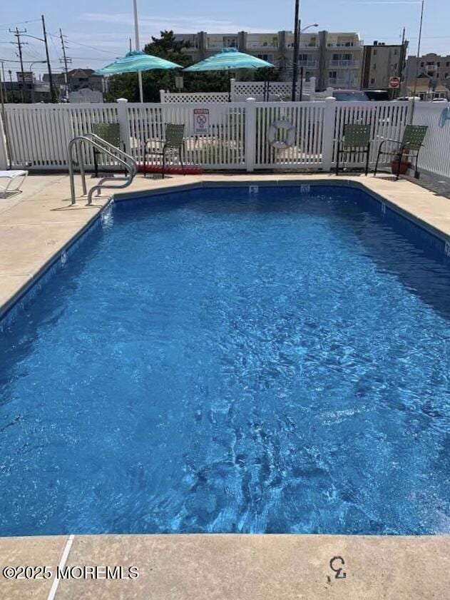 pool featuring fence and a patio