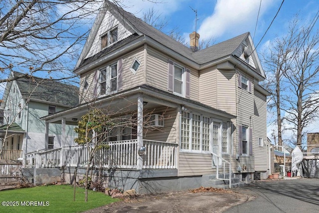 view of front of property with a porch and a chimney