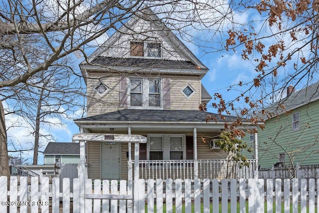 view of front of house featuring a fenced front yard, roof with shingles, and a porch