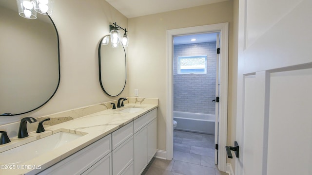 bathroom with double vanity, tile patterned flooring, toilet, and a sink