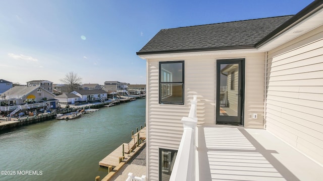 property entrance featuring a water view and roof with shingles