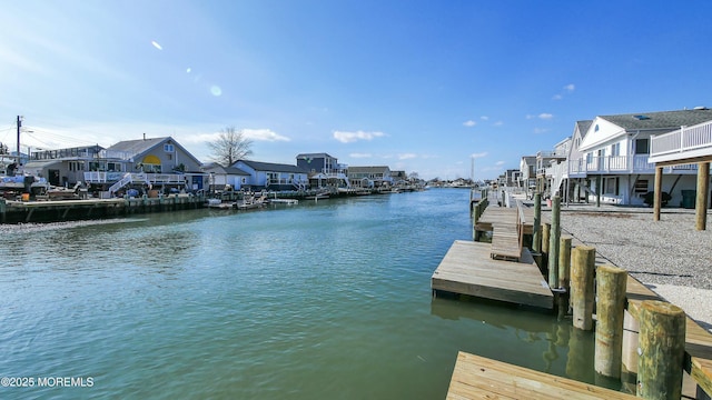 view of dock with a water view and a residential view