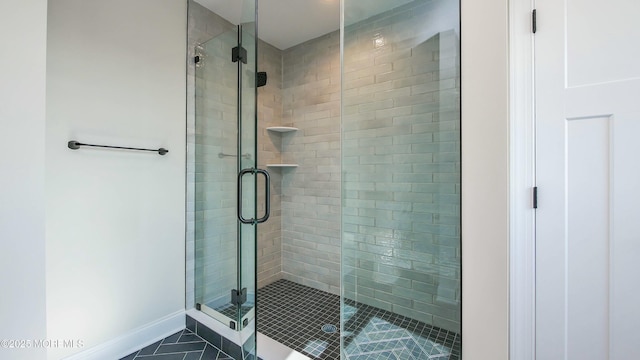 bathroom with a stall shower and baseboards