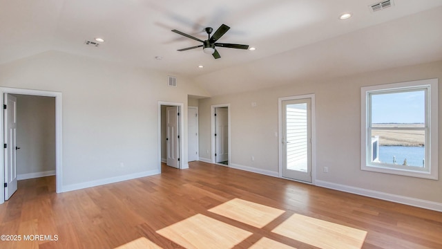 interior space with lofted ceiling, light wood-style floors, baseboards, and visible vents