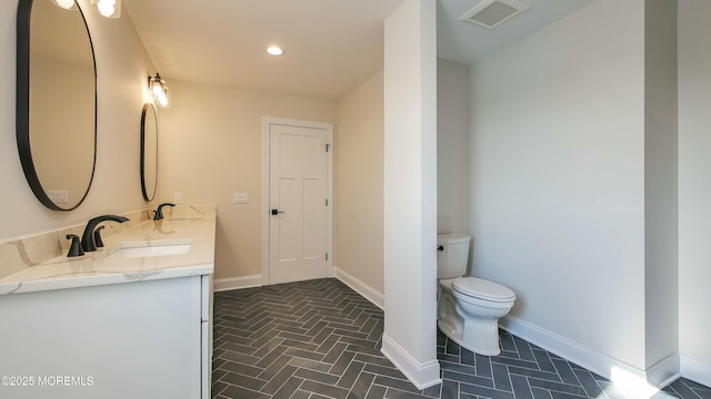 bathroom featuring baseboards, visible vents, a sink, and toilet