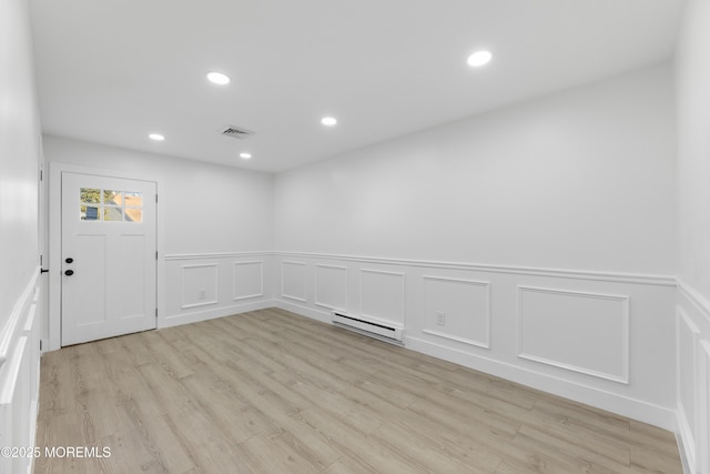 empty room featuring recessed lighting, a baseboard radiator, visible vents, and light wood-style floors