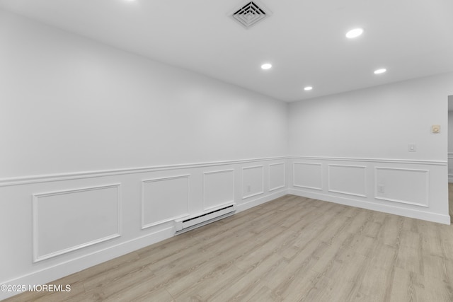 spare room with visible vents, recessed lighting, light wood-type flooring, and a baseboard radiator