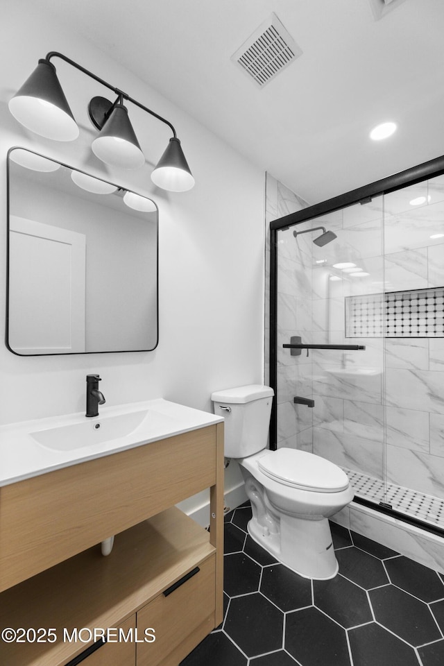 full bathroom featuring a marble finish shower, visible vents, tile patterned flooring, toilet, and vanity