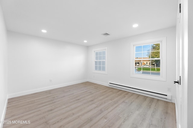 empty room featuring recessed lighting, visible vents, baseboard heating, and light wood-style flooring