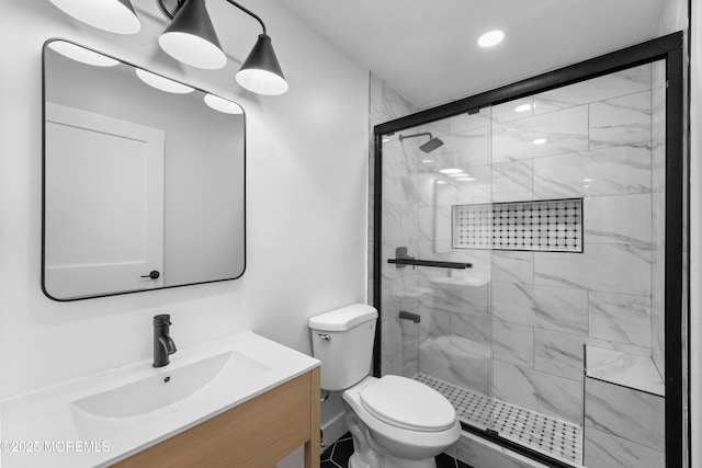 bathroom with toilet, a stall shower, and vanity