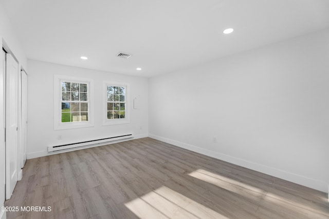 interior space with light wood-type flooring, visible vents, baseboard heating, and recessed lighting