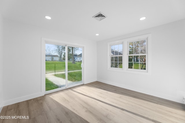 empty room with recessed lighting, visible vents, baseboards, and wood finished floors