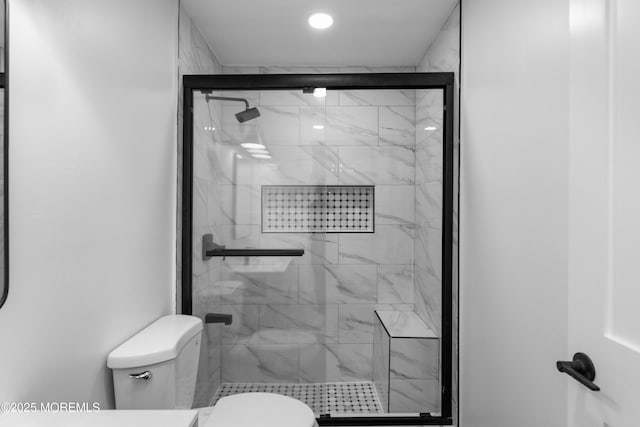 bathroom featuring toilet and a stall shower