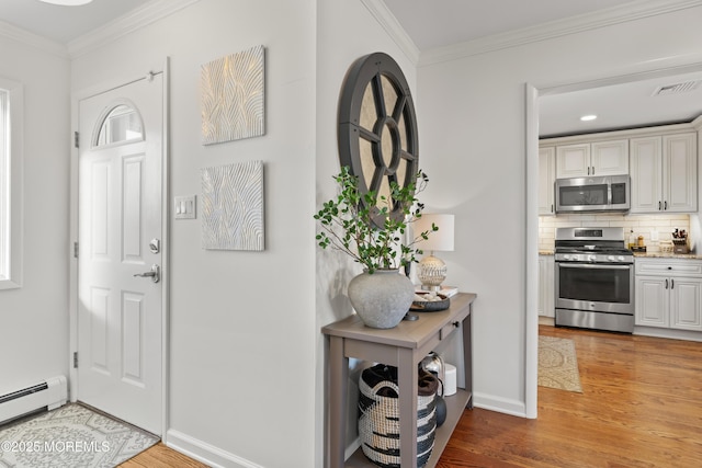 foyer entrance with a baseboard heating unit, light wood-type flooring, and crown molding