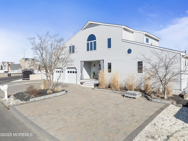 view of front of property featuring a garage and decorative driveway