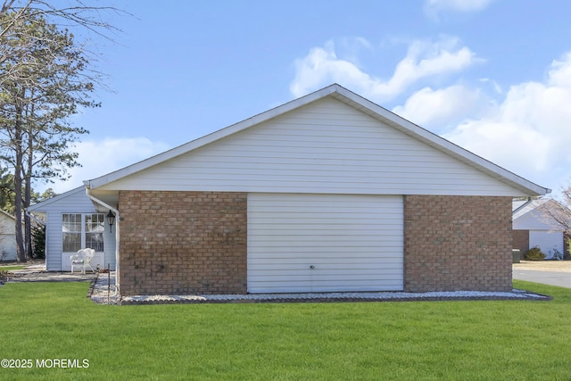 view of property exterior featuring a yard and brick siding