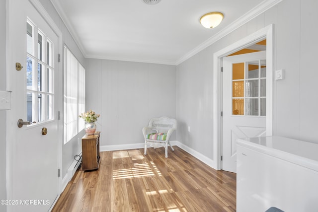 sitting room featuring ornamental molding, wood finished floors, and baseboards