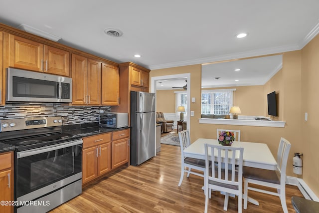 kitchen with appliances with stainless steel finishes, decorative backsplash, visible vents, and brown cabinets