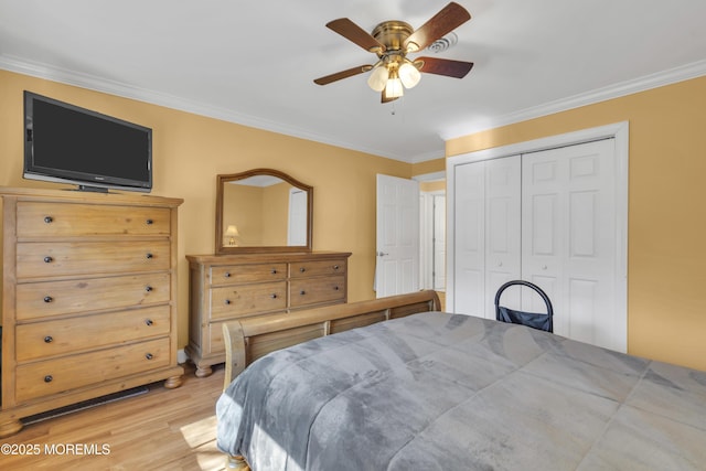 bedroom with light wood-style floors, a closet, crown molding, and ceiling fan