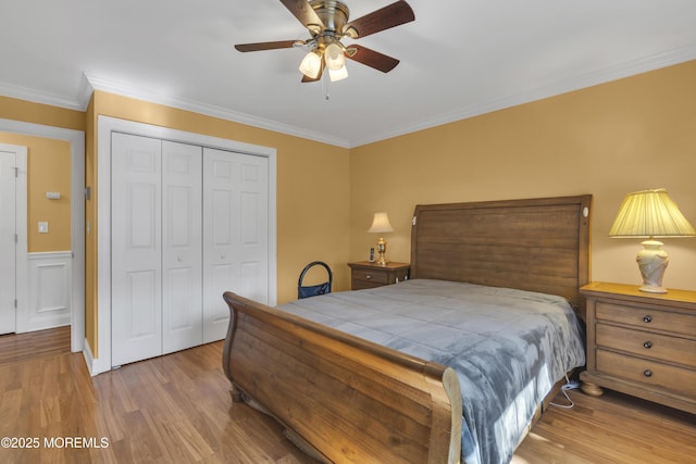 bedroom with ornamental molding, a ceiling fan, a closet, and wood finished floors