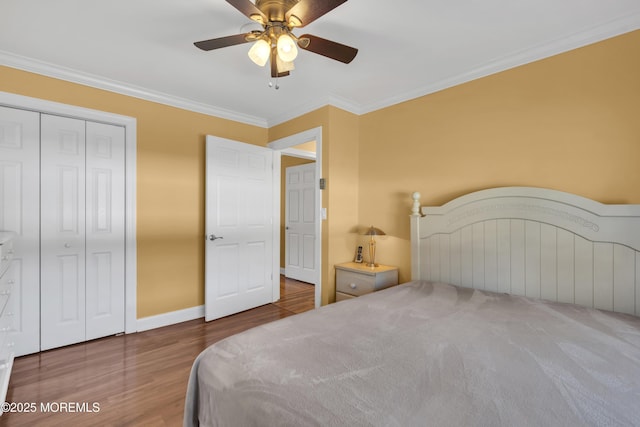 bedroom with wood finished floors, a ceiling fan, baseboards, ornamental molding, and a closet