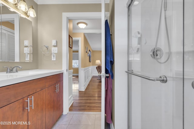 full bathroom featuring a stall shower, wainscoting, tile patterned flooring, and vanity