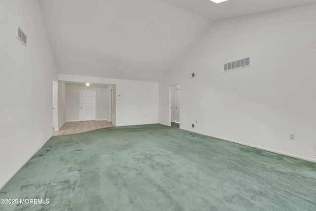 empty room with visible vents, carpet floors, and high vaulted ceiling