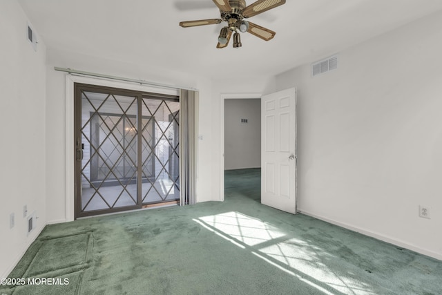 carpeted empty room with visible vents, baseboards, and ceiling fan