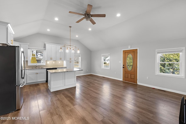 kitchen with a healthy amount of sunlight, a center island, a sink, and freestanding refrigerator