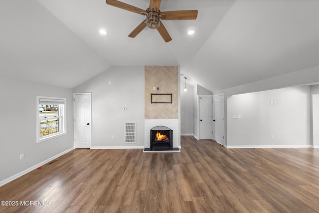 unfurnished living room with lofted ceiling, a fireplace, wood finished floors, and visible vents